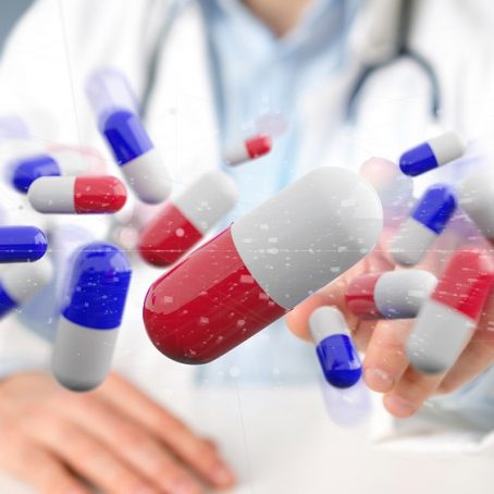 View of a Doctor holding  a 3d rendering group of medical pills